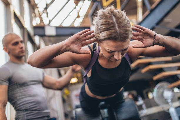 istock Trainer exercising with young woman in the gym 1048401152