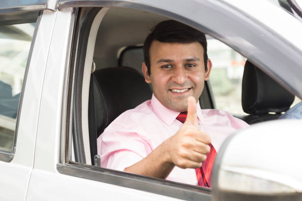 istock Smiling man driving in car - Stock image 1048401322