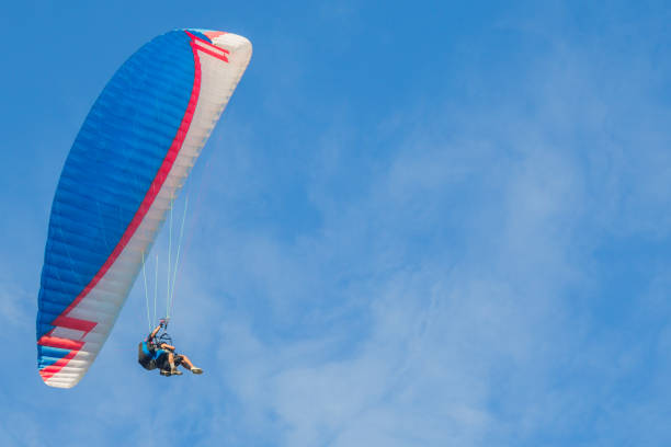 istock Paraglider soars against a blue sky. Tandem 1048402638