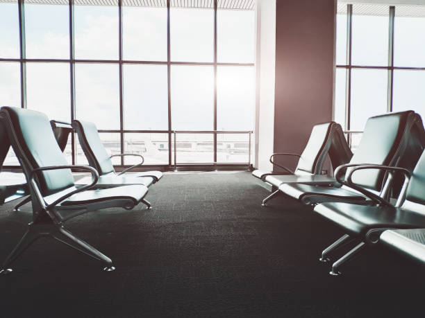 istock Empty bench in airport terminal.Passenger waiting area.selective focus and Sun flare effect. 1048405300