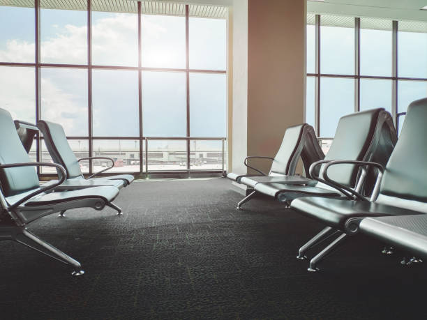 istock Empty bench in airport terminal.Passenger waiting area.selective focus and Sun flare effect. 1048405530