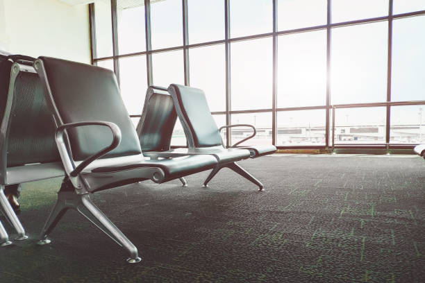 istock Empty bench in airport terminal.Passenger waiting area.selective focus and Sun flare effect. 1048405550