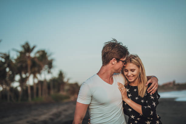 istock Beautiful young couple walking on the beach 1048419386