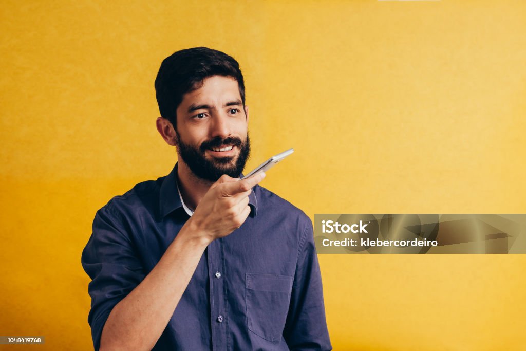 Leisure, technology, communication and people concept - young man using voice command recorder or calling on smartphone Talking Stock Photo