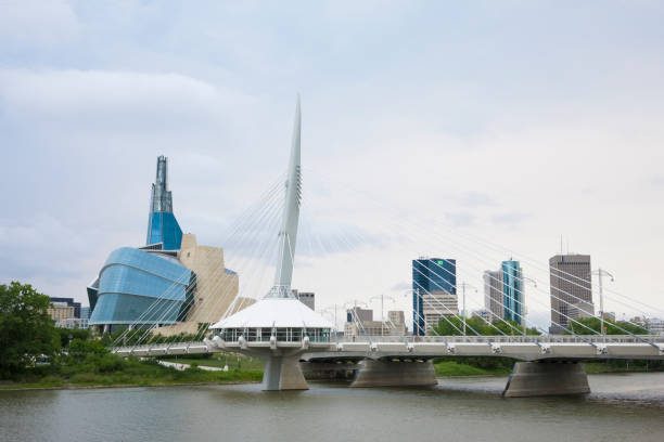 canadian museum of human rights and esplanade riel bridge in winnipeg, manitoba, canada - winnipeg river imagens e fotografias de stock