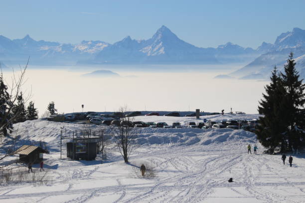 Magnificent view of the alps in winter, seen from the top of the mountain Gaisberg, Salzburg, Austria. Magnificent view of the alps in winter, seen from the top of the mountain Gaisberg, height approx. 1300 m.  A layer of high fog above  the valley of Salzburg. People enjoy the view.  Austria, Europe. gaisberg stock pictures, royalty-free photos & images