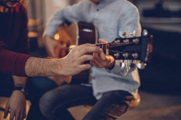 istock Boy teaching to play guitar in music school 1048435398