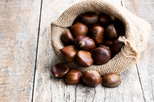 istock Fresh chestnuts in sack bag on the old wooden table 1048435474