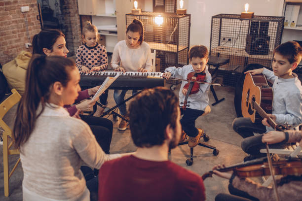 grupo de niños tocando instrumentos en la escuela de música - practicing music violin women fotografías e imágenes de stock