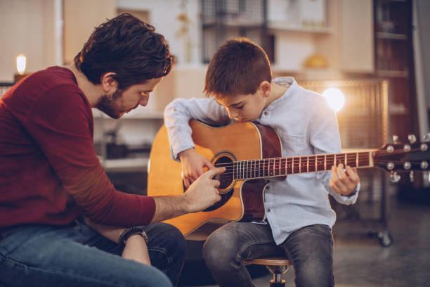 istock Boy teaching to play guitar 1048436392