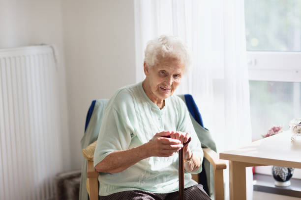 istock senior woman at home with walking cane 1048442398