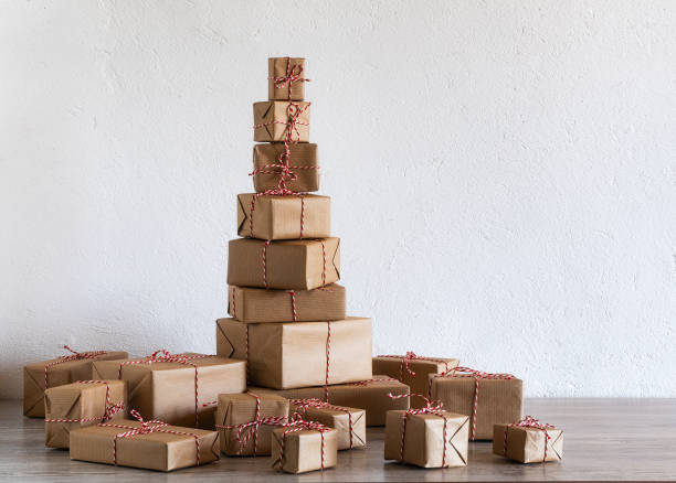 クリスマス プレゼントの山が壁に素朴な紙に包まれました。 - christmas gift giftwrap old fashioned ストックフォトと画像