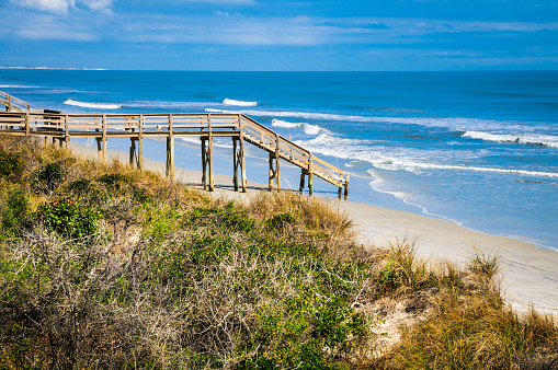 A wooden walkway and stairs lead to an empty beach in St. Augustine, Florida
