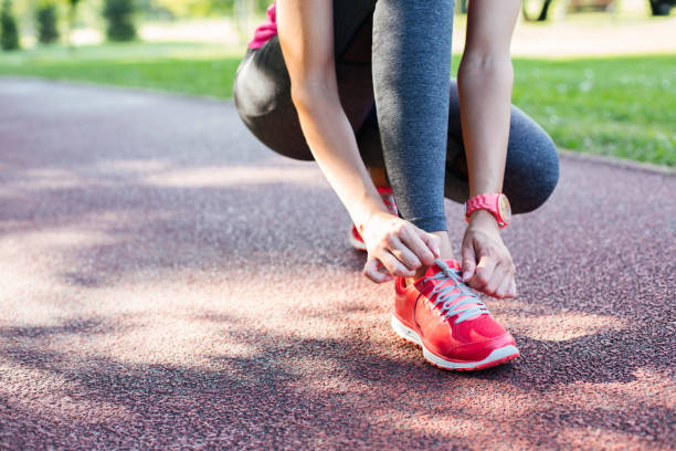 istock sportswoman tying shoelaces 1048454448