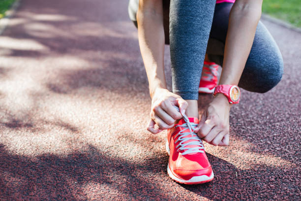 istock sportswoman tying shoelaces 1048454464