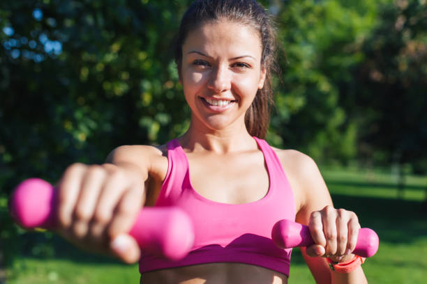 istock sporty girl holding weights 1048454670