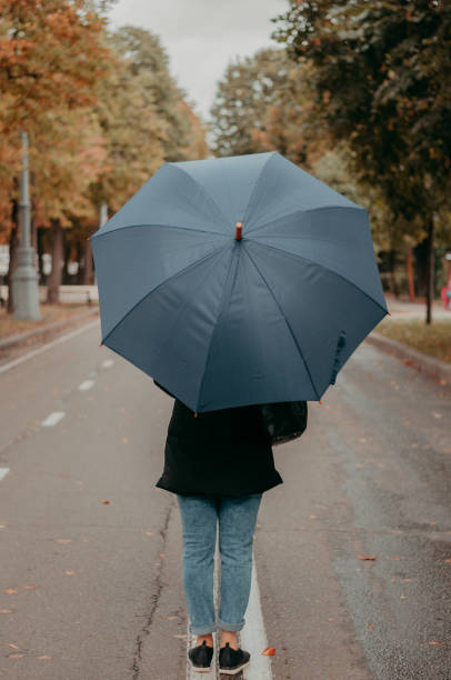 istock Woman with umbrella in autumn 1048467136