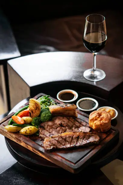 Photo of gourmet sunday roast beef traditional british meal set on old wooden pub table