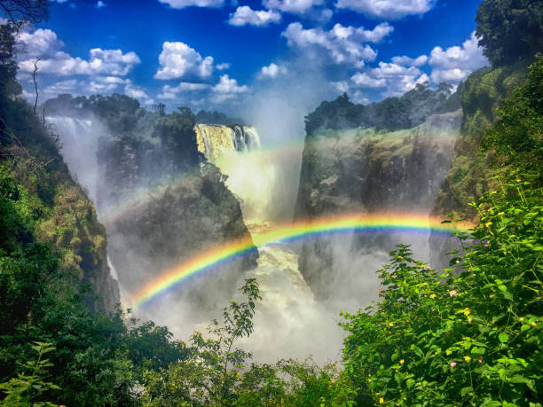 Double Rainbow at Victoria Falls in Zambia Bright sunlight of the dry season creates spectacular rainbows at the famous natural area of Victoria Falls in Zambia, Africa landscape fog africa beauty in nature stock pictures, royalty-free photos & images