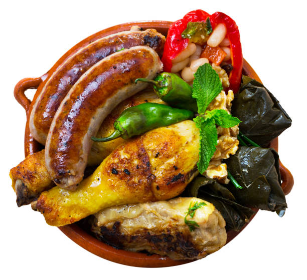 Top view of Bulgarian dish Kapama Top view of Bulgarian dish Kapama from mixed stewed meat and sausages with stuffed vegetables served in clayware. Isolated over white background kapama reserve stock pictures, royalty-free photos & images
