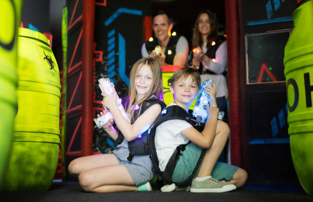 istock Kids sitting back to back with laser guns 1048492074