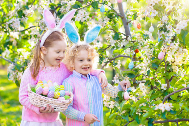 istock Easter egg hunt. Kids with bunny ears and basket. 1048494430
