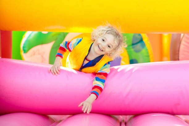 istock Child jumping on playground trampoline. Kids jump. 1048494614