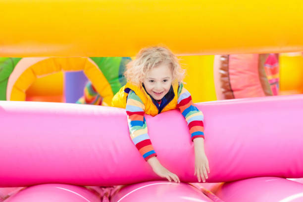 istock Child jumping on playground trampoline. Kids jump. 1048497306