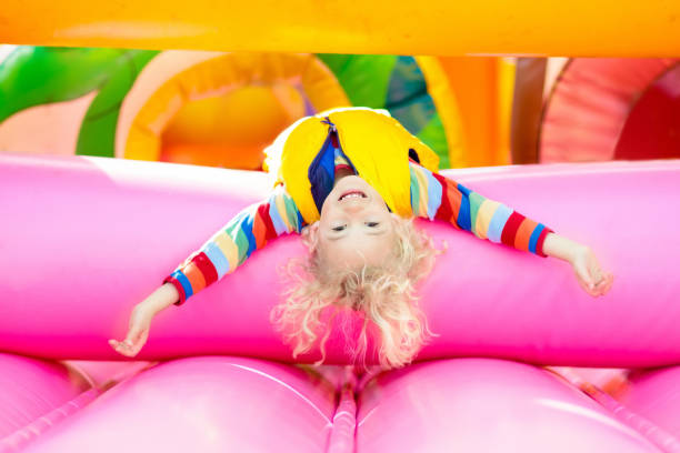 child jumping on playground trampoline. kids jump. - inflatable child playground leisure games imagens e fotografias de stock