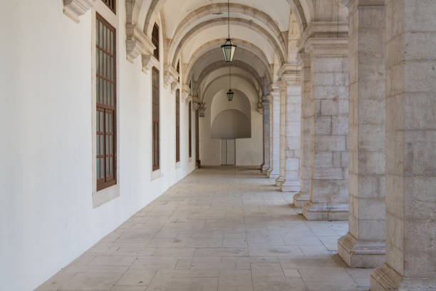 istock Long passageway moving to perspective under arches with stone block columns on one side and a white wall on the other side 1048500250