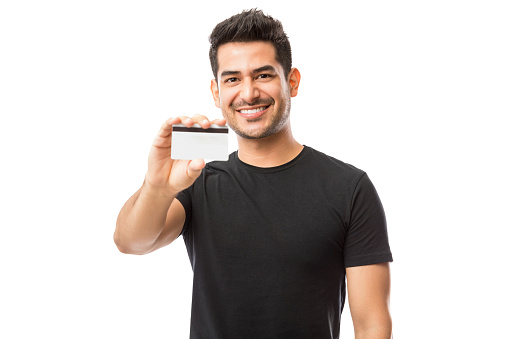 Attractive guy promoting credit card while standing against white background