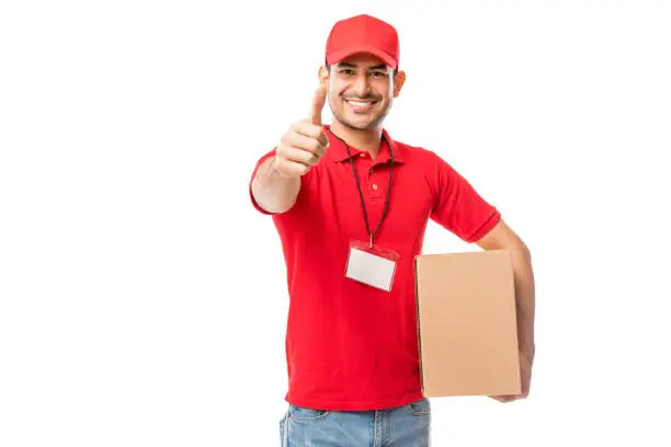 Photo of Confident Courier Man With Moving Box Showing Thumbs Up