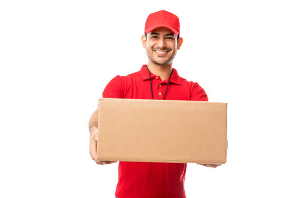 guapo joven usando el paquete de entrega de uniforme rojo - box men holding isolated fotografías e imágenes de stock