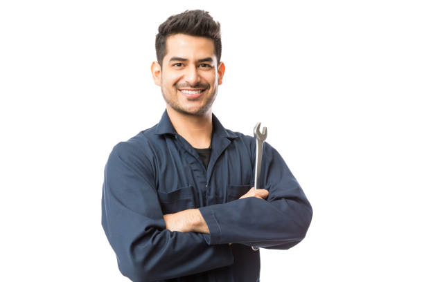 mecánico con una llave de pie manos dobladas sobre fondo blanco - mechanic fotografías e imágenes de stock