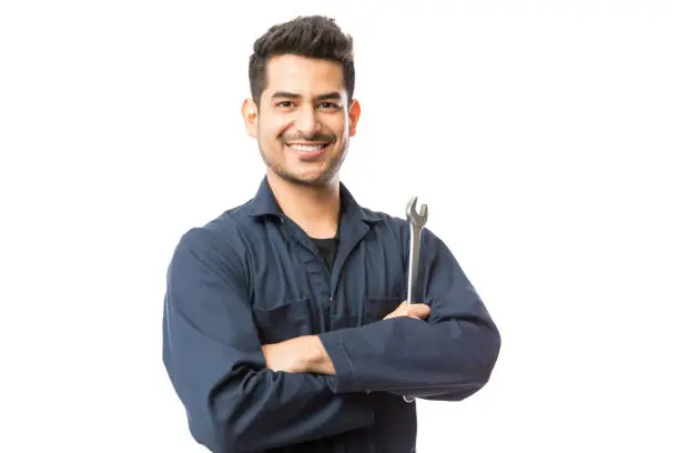 Photo of Mechanic With Wrench Standing Hands Folded On White Background