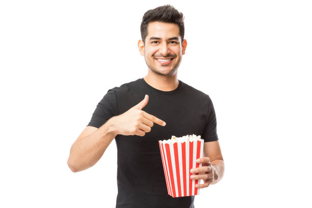 istock Smiling Attractive Male Pointing At Popcorn Bucket 1048532214