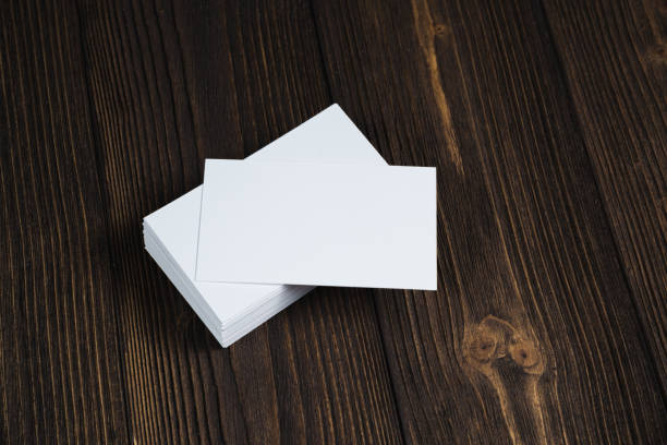 istock Blank business cards on wooden working table with copy space for add text ID. and logo, business company concept. 1048545410