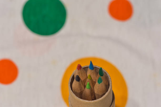istock Colored pencils inserted in a cardboard cylinder on a colored plane, horizontal image 1048551466