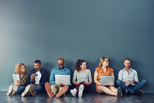 Studio shot of a diverse group of people social networking against a gray background