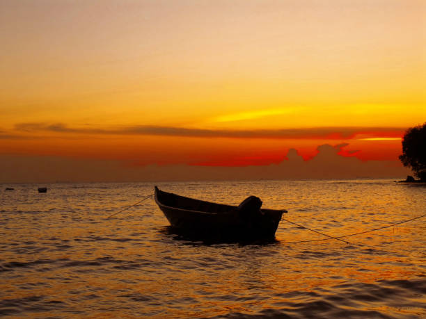 A peaceful sunset over a boat in Port Dickson