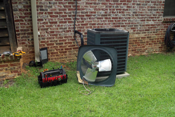 Air Conditioner Condenser coil with tools being repaired Air Conditioner compressor condenser coil with fan and tools being worked on next to a brick house for repair maintenance. condenser stock pictures, royalty-free photos & images