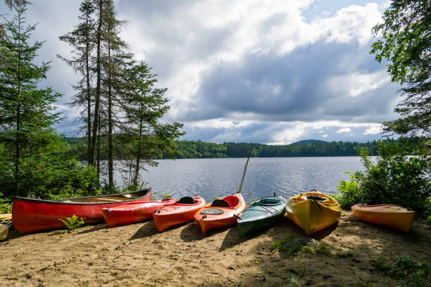 Kayaks and a canoe by the Indian lake in upstate NY (USA) The Adirondack Mountains in NY state (USA)  contain multiple lakes and forests pine tree lumber industry forest deforestation stock pictures, royalty-free photos & images