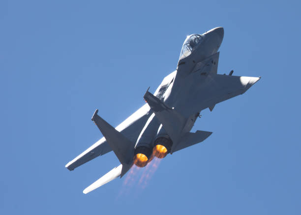 istock F-15 Eagle in a very close rear view, with afterburners on, against the light 1048579746
