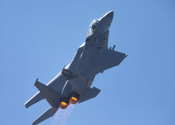 istock F-15 Eagle in a very close rear view, with afterburners on, against the light 1048579886