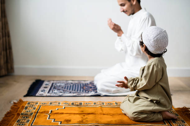 istock Muslim boy learning how to make Dua to Allah 1048593264