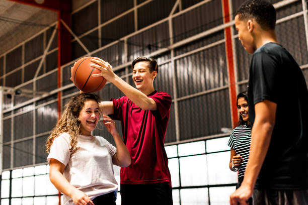 gruppo giocoso di amici adolescenti su un campo da basket - hanging basket foto e immagini stock