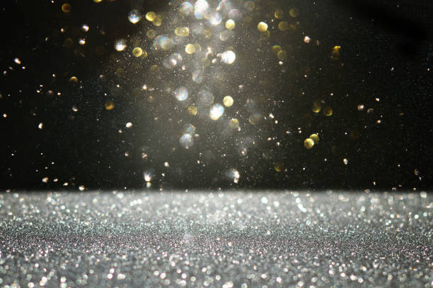 istock glitter vintage lights background. black, gold and silver. de-focused. 1048619390