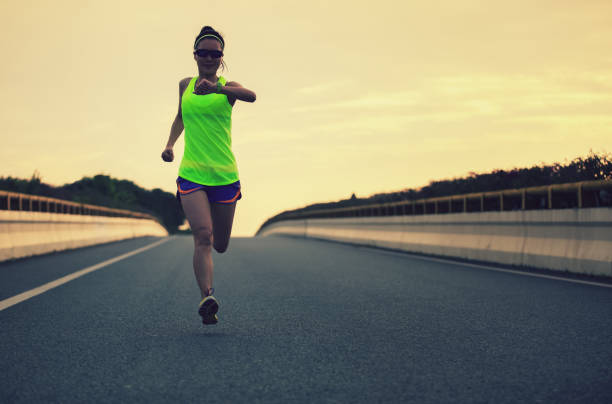 istock Female Runner athlete running on road. 1048632888