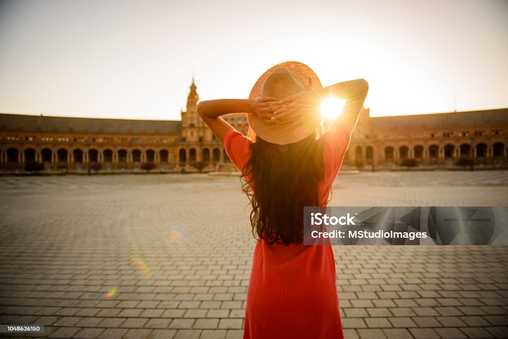 Woman enjoying sunrise. Woman enjoying sunrise above Plaza de Espana in Seville, Spain Seville Stock Photo