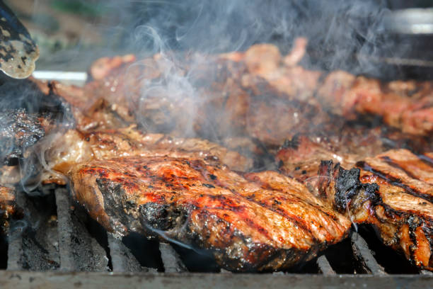 istock Meat steaks are cooked on a hot grill with smoke 1048641076